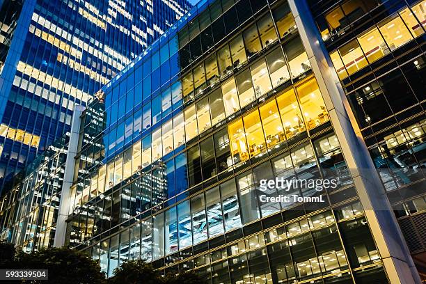 illuminated office buildings at canary wharf, london at night - office building stockfoto's en -beelden
