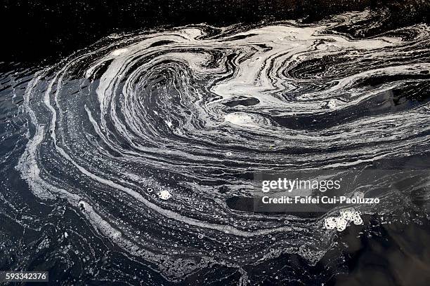 abstract foam line on water surface of crinan canal in scotland - watervervuiling stockfoto's en -beelden