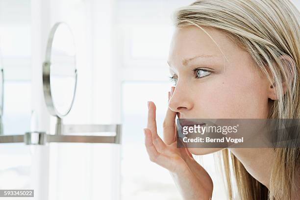 woman putting in contact lens - lente a contatto foto e immagini stock
