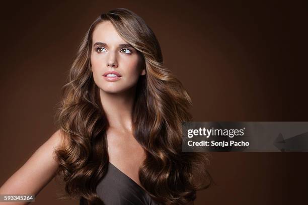 studio portrait of young woman with long brown hair - thick white women stock pictures, royalty-free photos & images