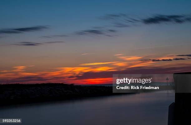 Sunset over Menemsha Sound in the town of Chilmark on Martha's Vineyard, MA over looking beach in the town of Aquinnah, formerly known at Gay Head on...