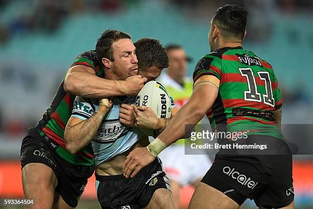 James Maloney of the Sharks is tackled during the round 24 NRL match between the South Sydney Rabbitohs and the Cronulla Sharks at ANZ Stadium on...