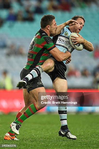 James Maloney of the Sharks is tackled by Samuel Burgess of the Rabbitohs during the round 24 NRL match between the South Sydney Rabbitohs and the...