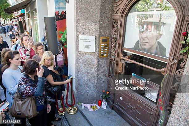 People are pictured after an unveiling ceremony of a plaque commemorating the musician David Bowie in the Hauptstrasse 155, where the artist lived...