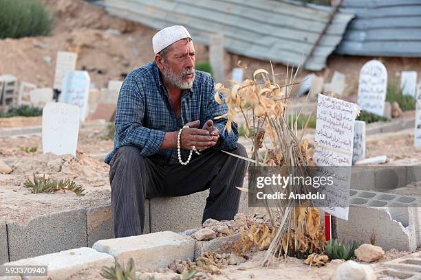 Syrian man Abdulkadir Salih al-Hatip, who lost his family members in Assad regime forces' chemical attack, prays at his relative's tomb during the...