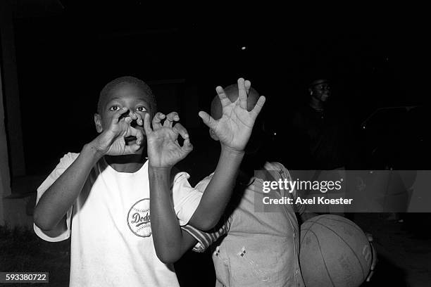 Members of the Grape Street Crips pose "throwing" their signature 'G' and 'W' hand signs. The Grape Street Watts Crips are a mostly African American...