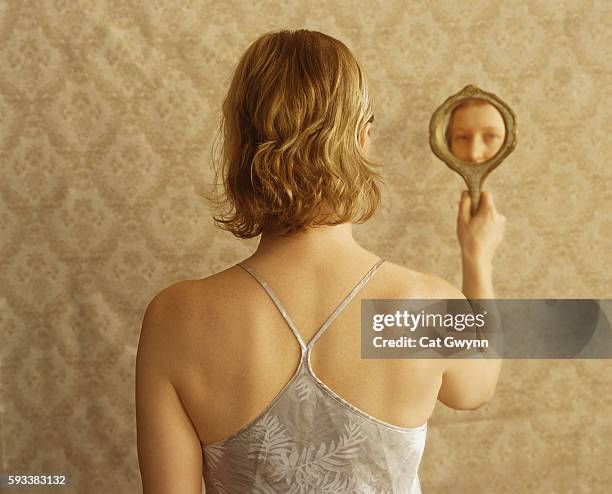 woman looking into hand mirror - vintage hand mirror stock pictures, royalty-free photos & images