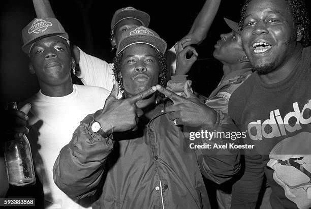 Members of the Grape Street Crips pose "throwing" their signature 'G' and 'W' hand signs. The Grape Street Watts Crips are a mostly African American...