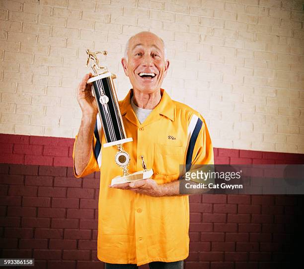 senior man holding bowling trophy - senior men bowling stock pictures, royalty-free photos & images