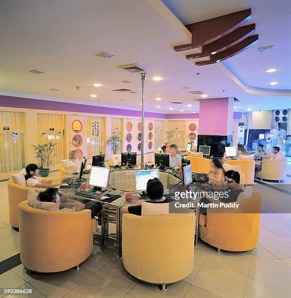 young people playing internet games and using internet in an internet cafe - internet cafe stockfoto's en -beelden
