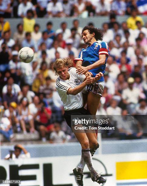 French football player Michel Platini wins a heading duel against his German opponent Wolfgang Rolff , during the World Cup football match between...