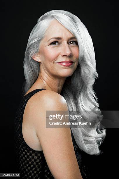 woman with a soft smile and long, gray hair. - portraits studio smile stockfoto's en -beelden