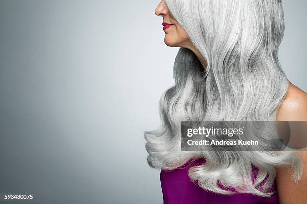 cropped profile of a woman with long, gray hair. - white hair stock-fotos und bilder