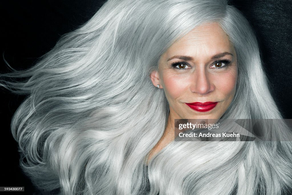 Woman with big, wavy, silver gray hair, portrait.