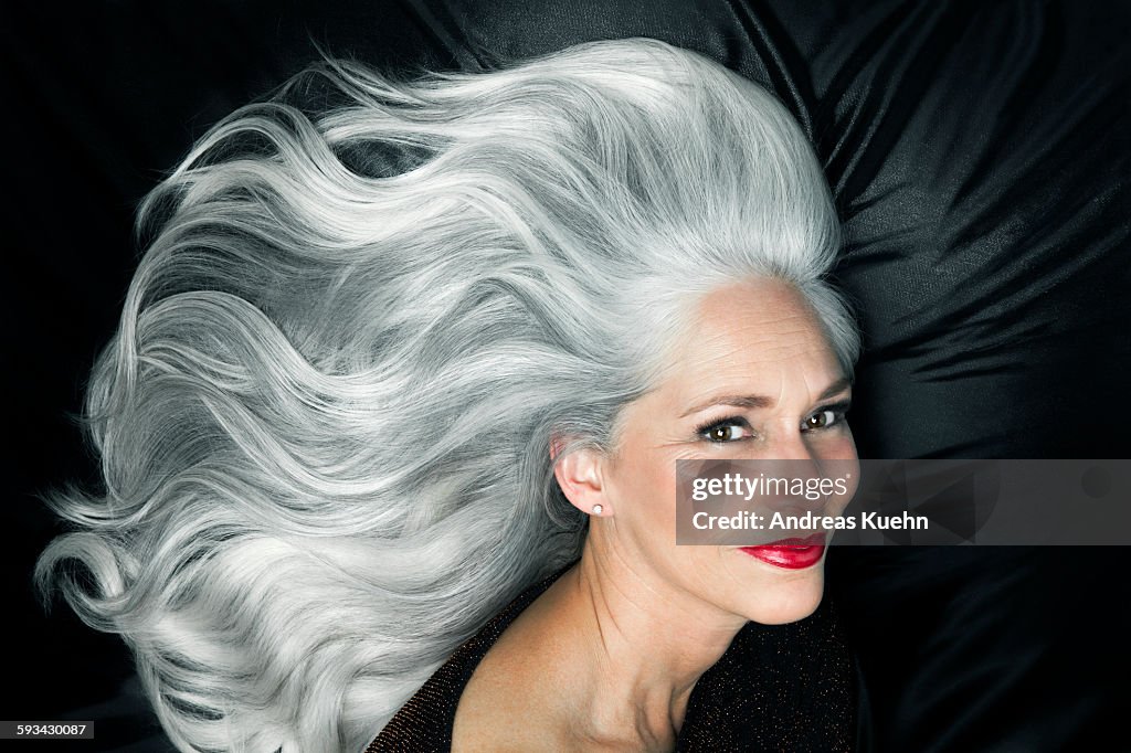 Glamorous portrait of a woman with long gray hair.