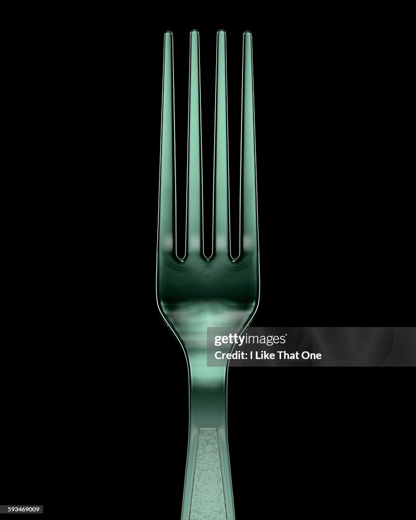 Plastic fork against a black background