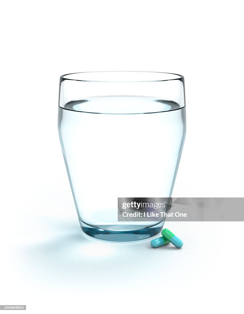 Glass of water and two pills / medication