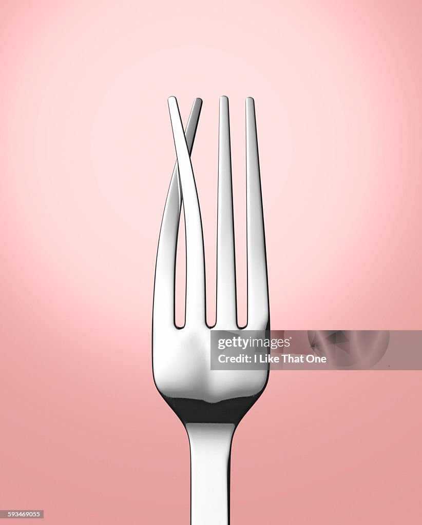 Silver eating fork with prongs crossed