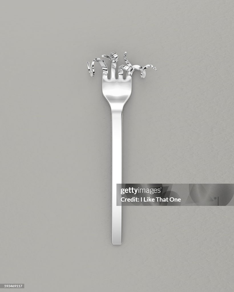 Silver fork with bent prongs on grey background