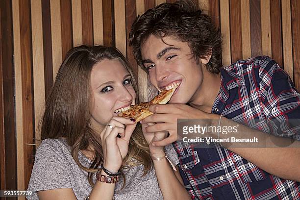 two teenager eating a pizza - vincent young stock pictures, royalty-free photos & images