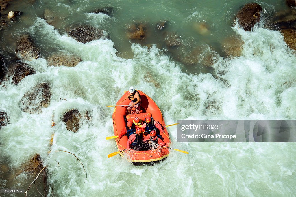 Rubber dinghy with tourists doing rafting in Trentino, Italy.