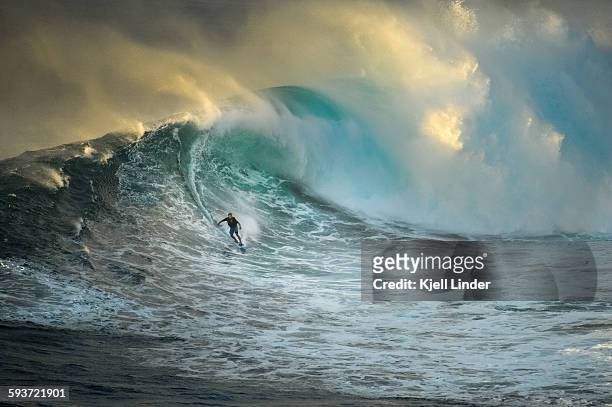 surfer on a big wave at jaws - isla de hawai fotografías e imágenes de stock