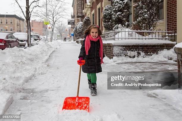 little girl shoveling snow in winter - snow shovel stock pictures, royalty-free photos & images