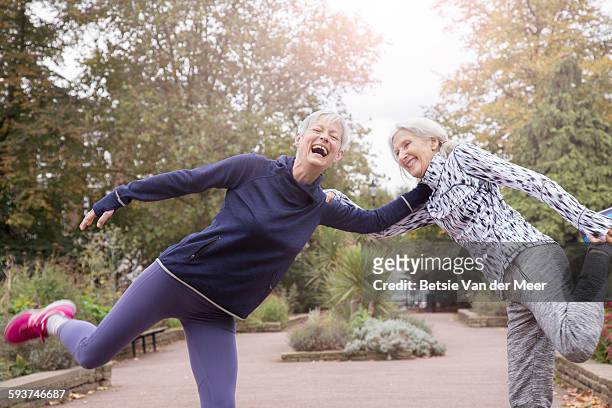 senior women stretching legs in park. - on one leg stock pictures, royalty-free photos & images