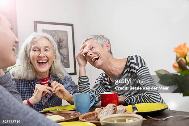 women laughing, having lunch at home. - kaffeeklatsch stock-fotos und bilder