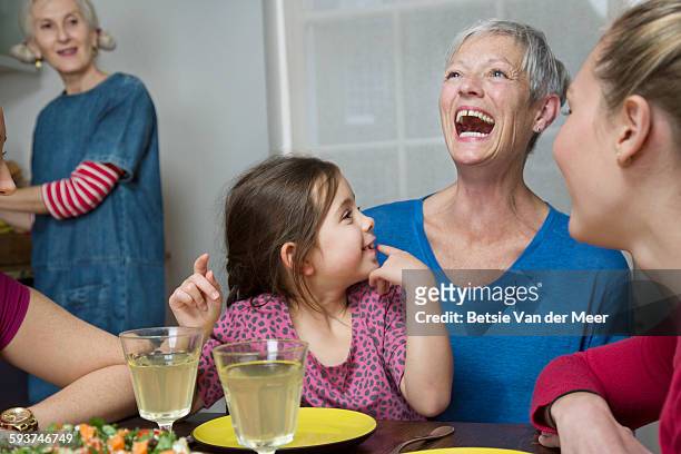 grandmother with grandchild and family at table. - retirement party stock pictures, royalty-free photos & images