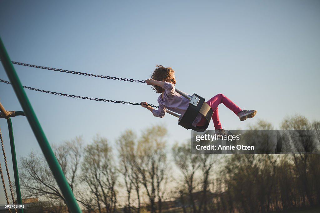 Girl swinging high into the sky