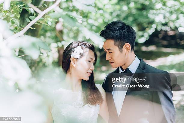 groom looking at beautiful bride - chinese wedding stock-fotos und bilder