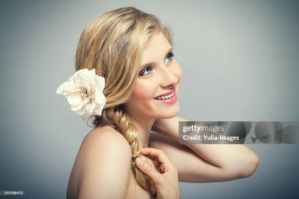 Smiling Young Woman Wearing Flower in Blond Hair