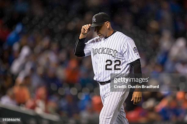 Walt Weiss of the Colorado Rockies adjusts his cap after making a pitching change in the 10th inning of a game against the Chicago Cubs at Coors...