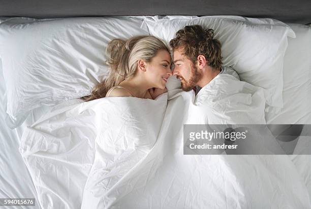 loving couple in bed - man and woman kissing in bed stock pictures, royalty-free photos & images
