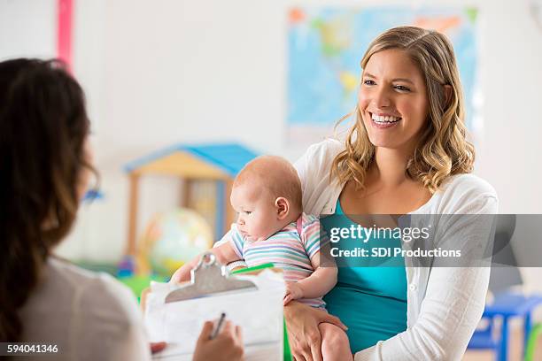 happy mom and baby getting tour of a daycare center - parent teacher conference stock pictures, royalty-free photos & images