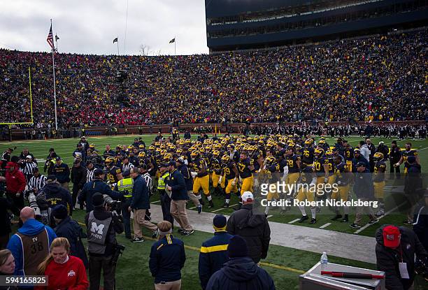 Unidentified fans and alumni of the University of Michigan watch as their team heads off at half time during the traditional Big Ten game over the...
