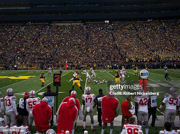 Unidentified fans and alumni of the University of Michigan and Ohio State University, foreground, cheer their football teams during the traditional...