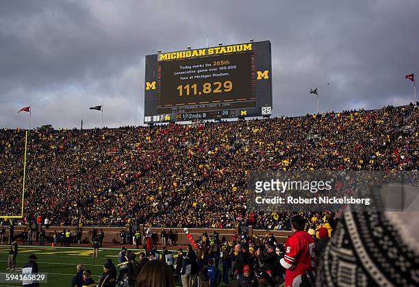 Unidentified fans and alumni of the University of Michigan and Ohio State University cheer their football teams during the traditional Big Ten game...