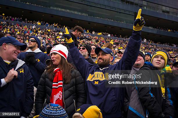 Unidentified fans and alumni of the University of Michigan and Ohio State University cheer their football teams during the traditional Big Ten game...
