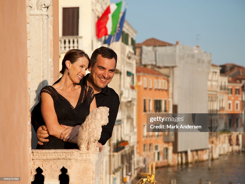 Italy, Venice, Mature couple embracing on balcony over canal