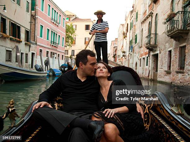 italy, venice, mature couple embracing in gondola - venedig gondel stock-fotos und bilder