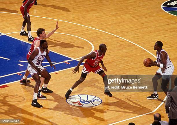 Michael Jordan of the Chicago Bulls guards Ron Anderson of the Philadelphia 76ers as Armen Gilliam of the 76ers battles with Will Perdue of the Bulls...