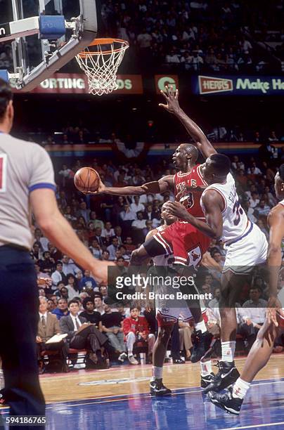 Michael Jordan of the Chicago Bulls goes for the layup against Armen Gilliam and Charles Barkley of the Philadelphia 76ers during a game in the 1991...