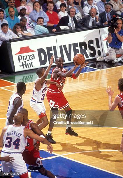 Michael Jordan of the Chicago Bulls looks to pass as he is defended by Hersey Hawkins of the Philadelphia 76ers duing a game in the 1991 Eastern...