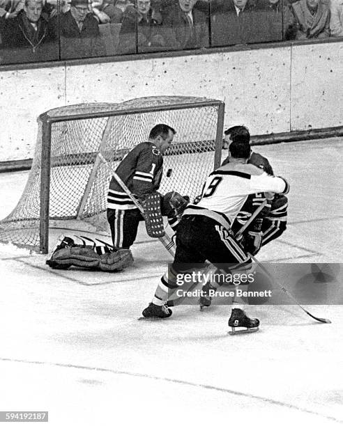 Goalie Glenn Hall of the Chicago Blackhawks makes the save on Johnny Bucyk of the Boston Bruins as Doug Jarrett of the Blackhawks defends on March 2,...