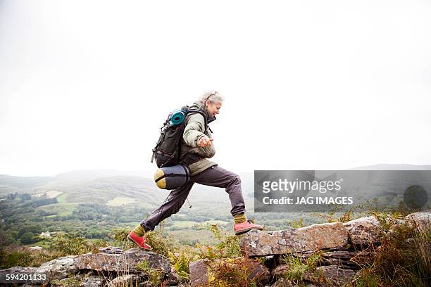 older woman trekking in the mountains of ireland - beautiful irish person stockfoto's en -beelden