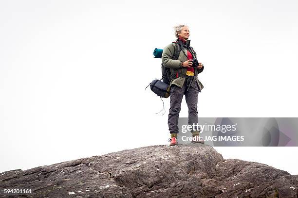 older woman trekking in the mountains of ireland - females hiking stock pictures, royalty-free photos & images