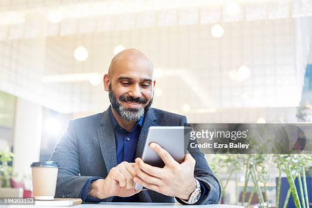 modern businessman using his tablet in an office. - content photos et images de collection