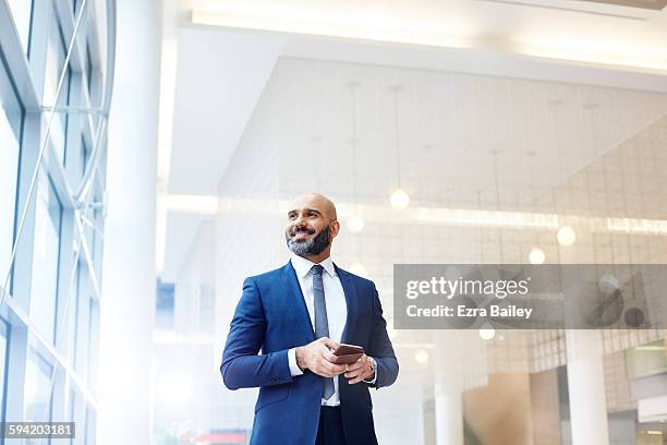 portrait of a modern businessman in a smart office - geschäftsmann im büro mobiltelefon stock-fotos und bilder